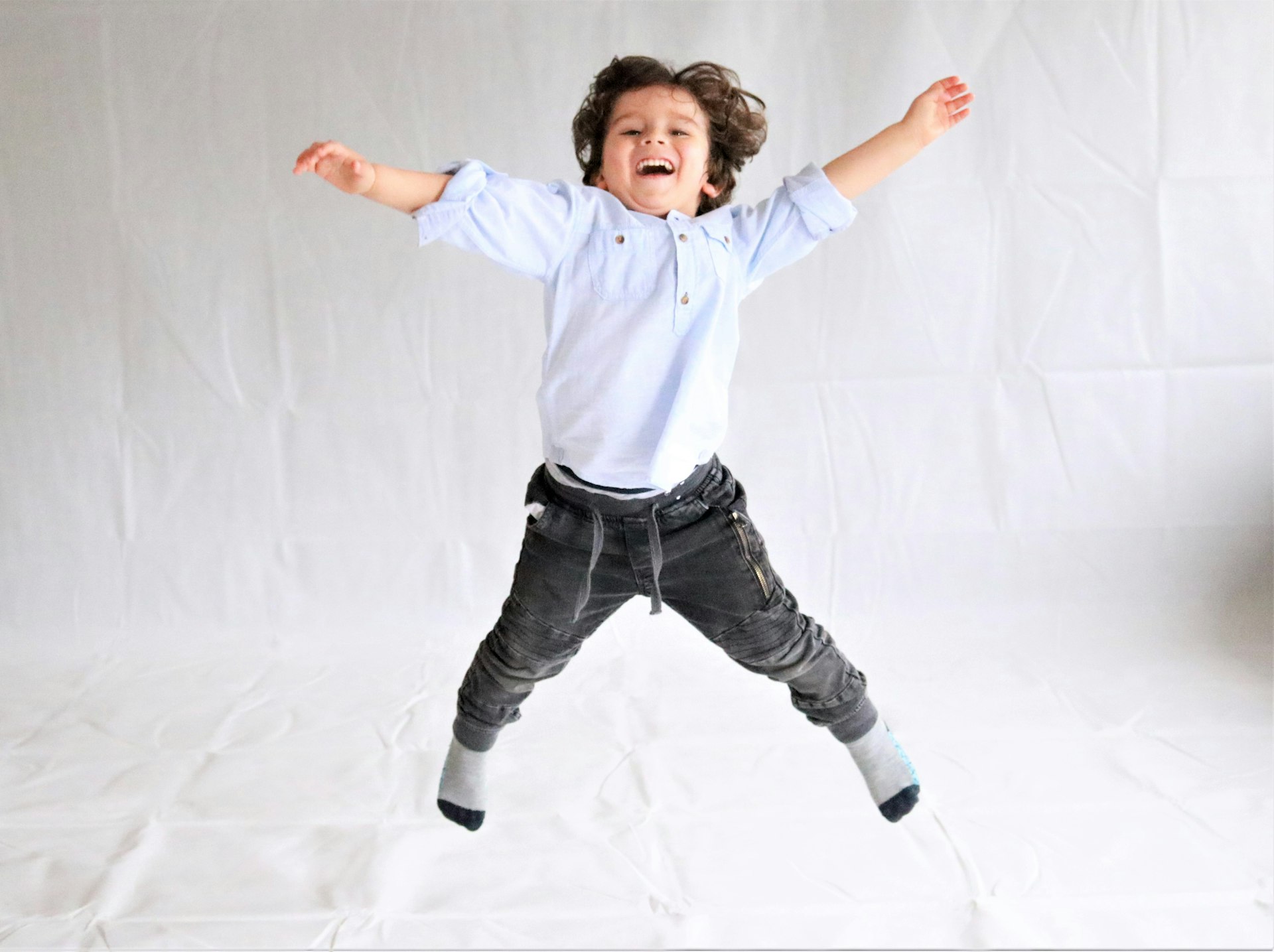 girl in white dress shirt and black pants jumping